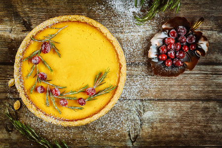 Beautiful pumpkin pie with cranberry on wooden background. Copy space.の写真素材