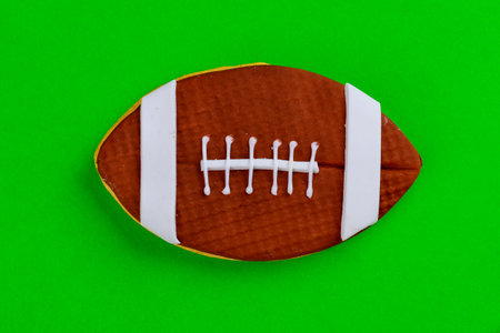 Close up of american football ball isolated on green background. Top view.の写真素材
