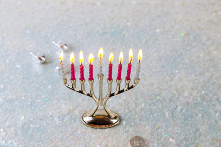 Jewish candlestick menorah with burning candles on sparkle background. Hanukkah holiday.
