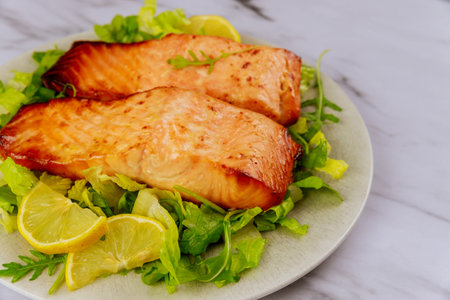 Baked salmon fillet with green salad on gray plate. Healthy food.の写真素材