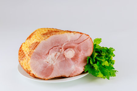 Whole pork ham with fresh celery isolated on white background. Easter dish.の写真素材