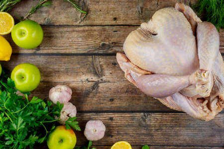 Raw turkey with cooking ingredients and spices on wooden surface. Top view.の写真素材