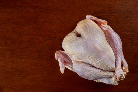 Raw fresh whole turkey isolated on wooden background.の写真素材