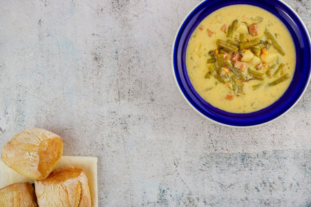 Healthy vegetable soup with bread in blue plate. Top view.