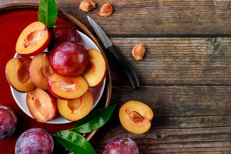 Juicy red plum on big plate. Top view.の写真素材