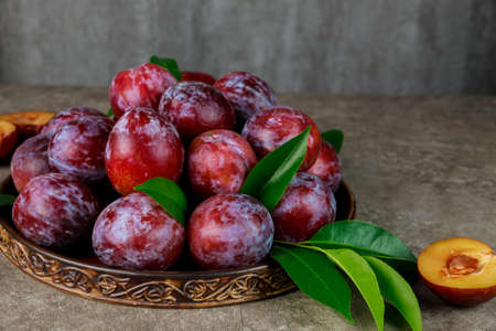 Sweet red plum on big plate. Close up.の写真素材