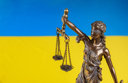 Lady Justice holding the scales on flag of Ukraine background. Russian terrorist attack.の写真素材