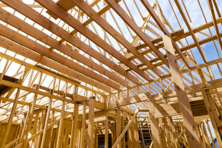 Framing beams of new home under construction in wooden roof trusses