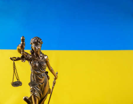 Lady Justice holding the scales on flag of Ukraine background. Russian terrorist attack.の写真素材