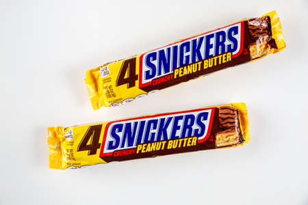 May 4, 2021. New York. Two Snickers bar with fresh roasted peanuts, caramel and nougat covered in white chocolate.のeditorial素材