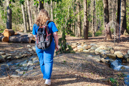 Young teenage girl with backpack hiking through a forest.の写真素材