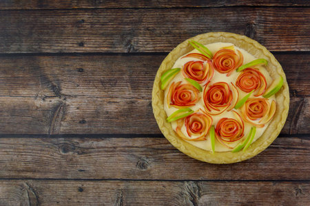 The top view of the apple pie rose shape on a rustic wooden background.の写真素材
