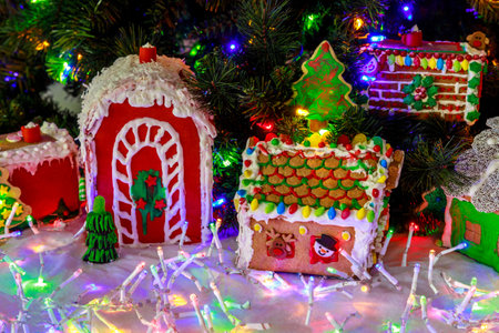 Christmas tree and colorful garlands decorate this gingerbread house.の写真素材