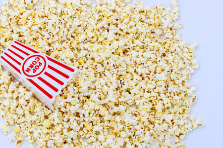 Popcorn box with white and red stripes and fluffy popcorn inside.の写真素材