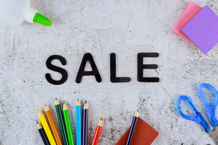 Word sale on light background with school supplies. Back to school.の写真素材