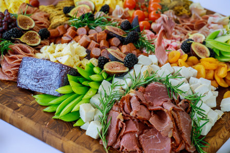 Charcuterie board with variety or assortment of cheese, fruits and deli. Full frame.の写真素材