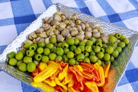 Marinated green olives with mushrooms and bell pepper in plate.の写真素材