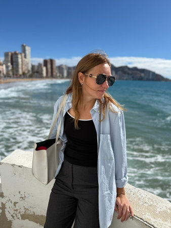 Benidorm, Spain. Beautiful female tourist standing on the promenade by the seaの写真素材