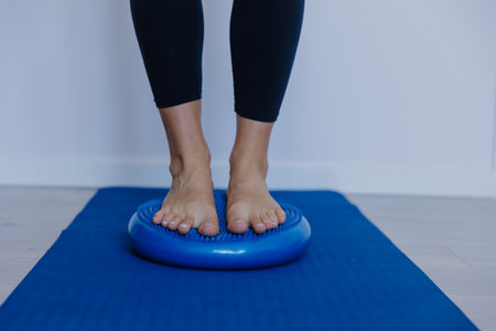 bare feet on inflatable stability cushion centered on mat, slow balance training with soft wobble, coreの写真素材