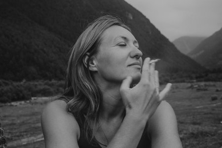 monochrome woman closing eyes in meditation, serene portrait with soft hands near face, grayscaleの写真素材