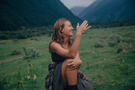 gesturing caucasian woman pointing toward valley, expressive guide role with conversational energy, bootsの写真素材