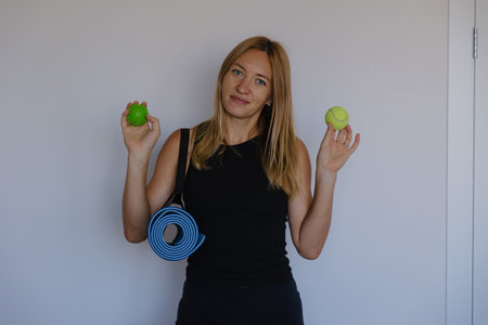 coach holding tennis balls, mat smiling at camera ready for playful hand warmup and light stretchingの写真素材