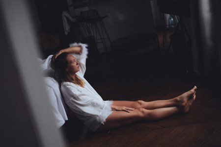 reclined bedroom pause caucasian woman resting against bedframe, hands behind head, eyes closed, vintageの写真素材