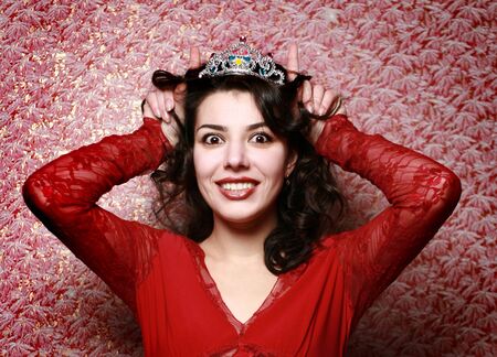 Beautiful girl posing on red wallpaper backgroundの写真素材