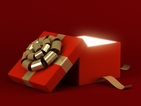 Gift box open with gold ribbon bow and light backgroundの写真素材