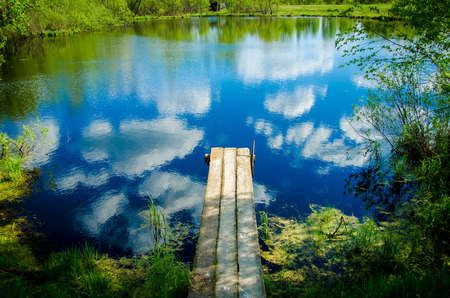 The old wooden pier in the sky with cloudsの写真素材