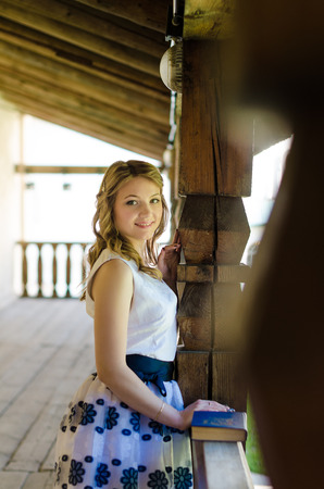 Beautiful woman holding a book standing on the stairsの写真素材