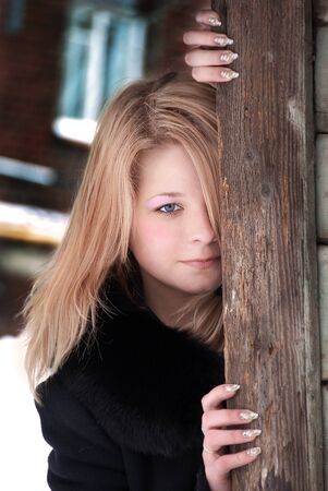 the girl looks out from behind the corner of the houseの写真素材
