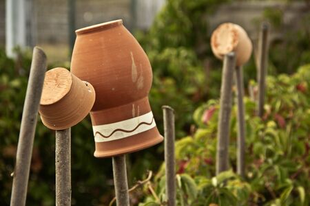 Rustic pottery jugs, pots hanging on the fenceの写真素材