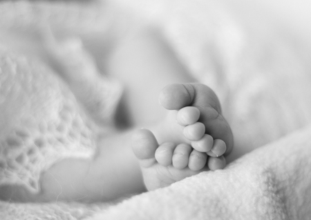 Tiny feet of a newborn baby. Shallow depth of field.の写真素材