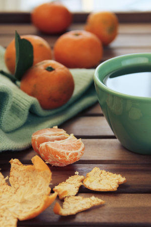 warming composition - Orange tangerine and mandarin slices, green cup of teaの写真素材