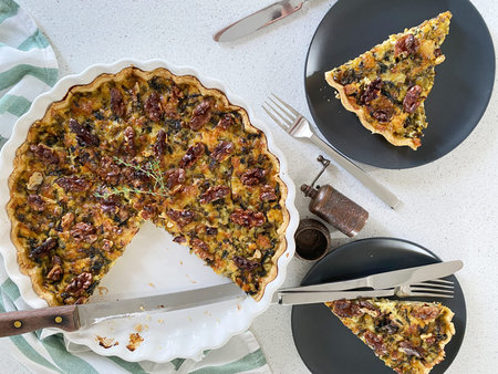Quiche with ricotta and dried tomatoes in a large white baking dish.