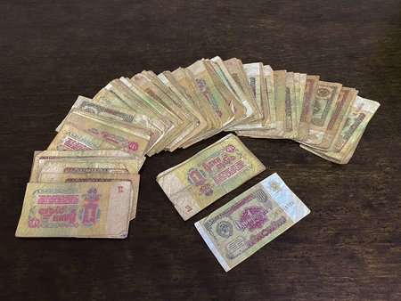 Old Soviet banknotes with a face value of one ruble lie like a fan on a wooden background. Finance...