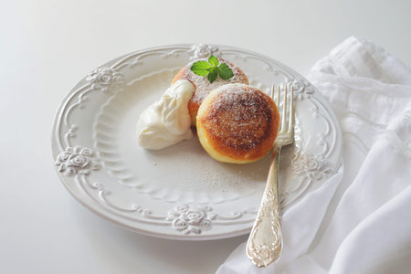 Cottage cheese pancakes, syrniki, ricotta fritters on white ceramic plate. Healthy and delicious morning breakfast. Copy space for text, food backgroundの写真素材
