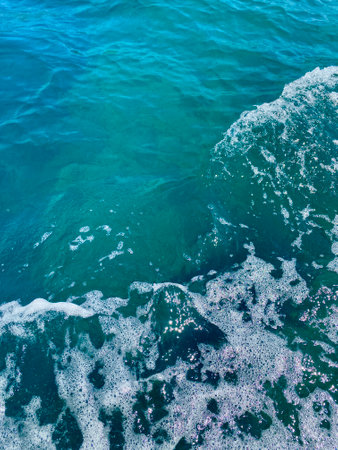 Turquoise sea close-up in bright sunlight. The concept of summer, vacation, travel.The purest clear blue water, small waves roll on the sandy shore. The texture of the seaの写真素材