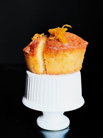 Freshly baked homemade lemon muffins, drizzled with lemon glaze and garnished with lemon zest
