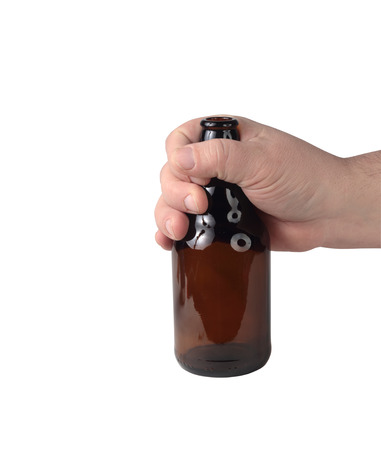 a small beer bottle in a hand on a white backgroundの写真素材