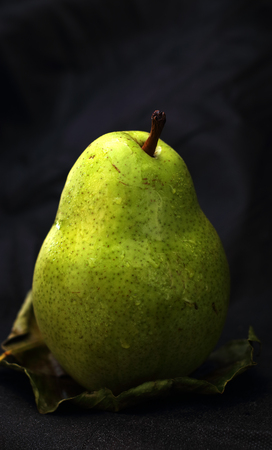 pear fruit on a leaf and a black backgroundの写真素材