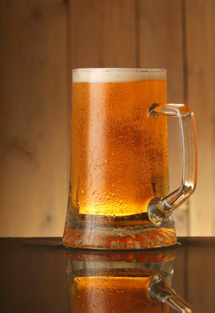full mug of beer on a background of wooden planks