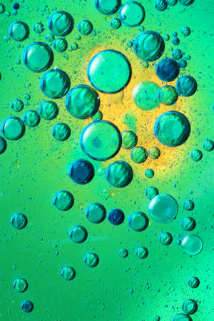 oil bubbles with water on glass and colored backgroundの写真素材