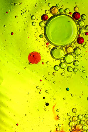 oil bubbles with water on glass and colored backgroundの写真素材
