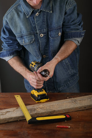 the person exchanges the drill bit in the screwdriver on the tableの写真素材