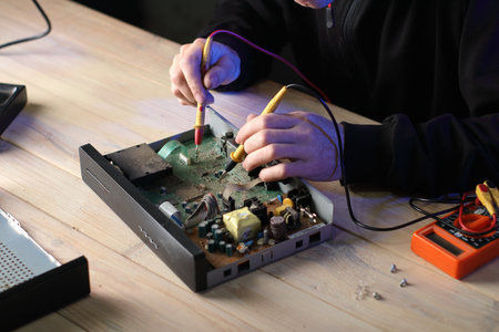 repair of an old satellite tuner by person on the table and gray backgroundの写真素材