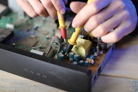 repair of an old satellite tuner by person on the table and gray backgroundの写真素材