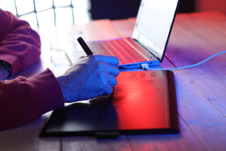 writing on a graphic tablet at the computer on a colored background