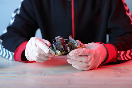 circuit board in hand over table and blue background